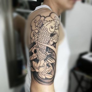 上海做餐饮生意的宋先生大臂上的莲花鲤鱼线条纹身图案